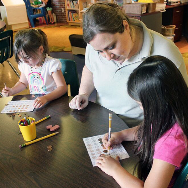 Woman helping students with writing activity